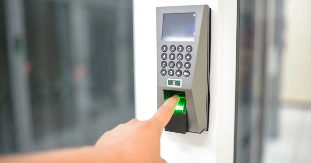 A finger touching a biometric access scanner.